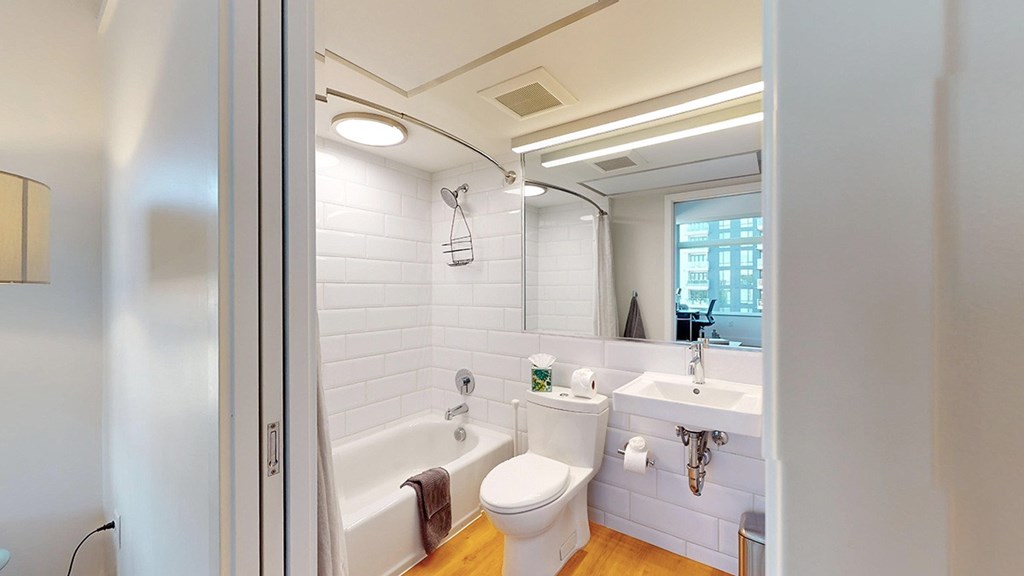 A white bathroom with a toilet, sink, and bathtub.