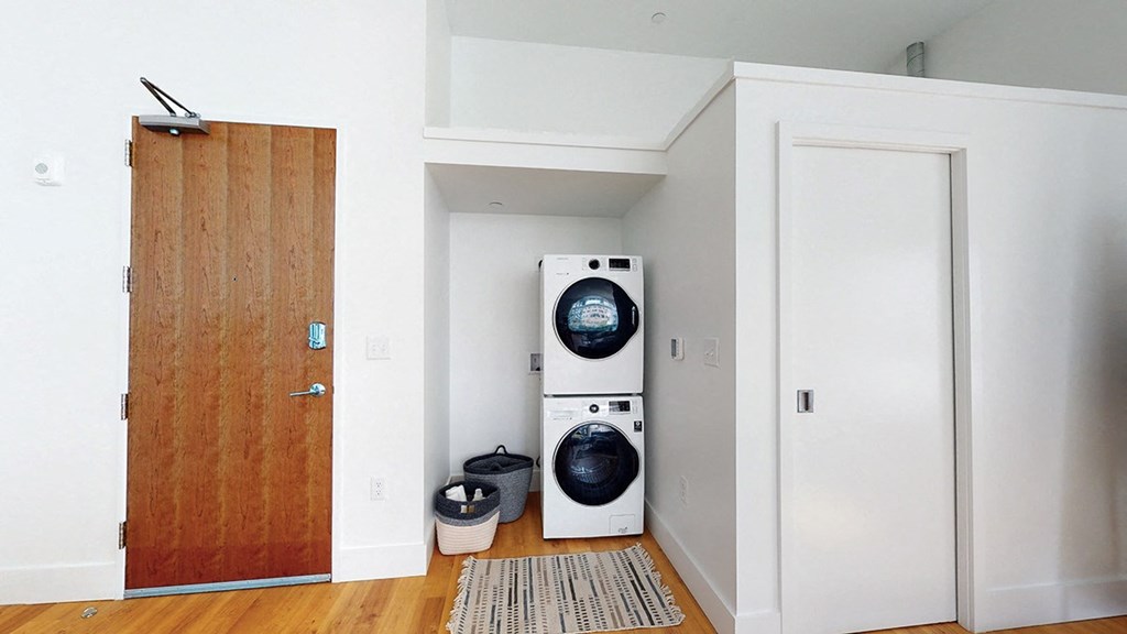 A laundry room with a washer and dryer stacked on top of each other.