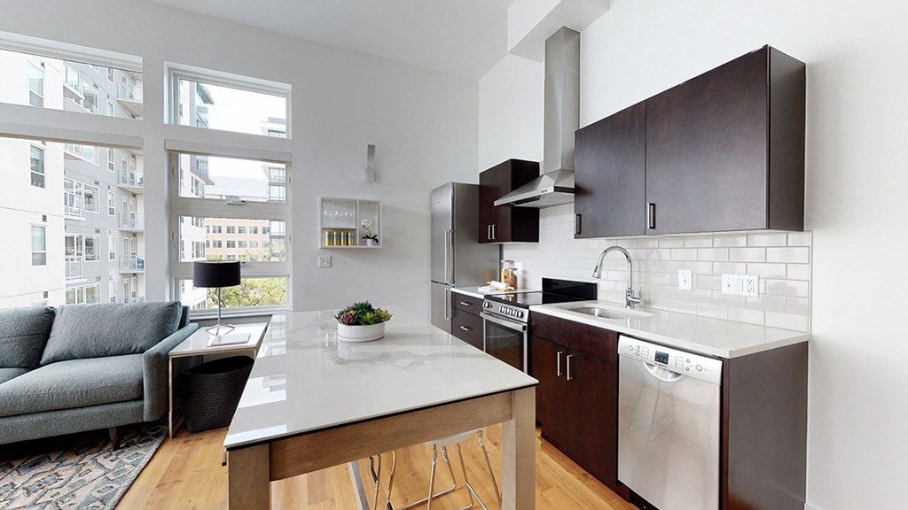 A modern kitchen with a large island and a view of the city.