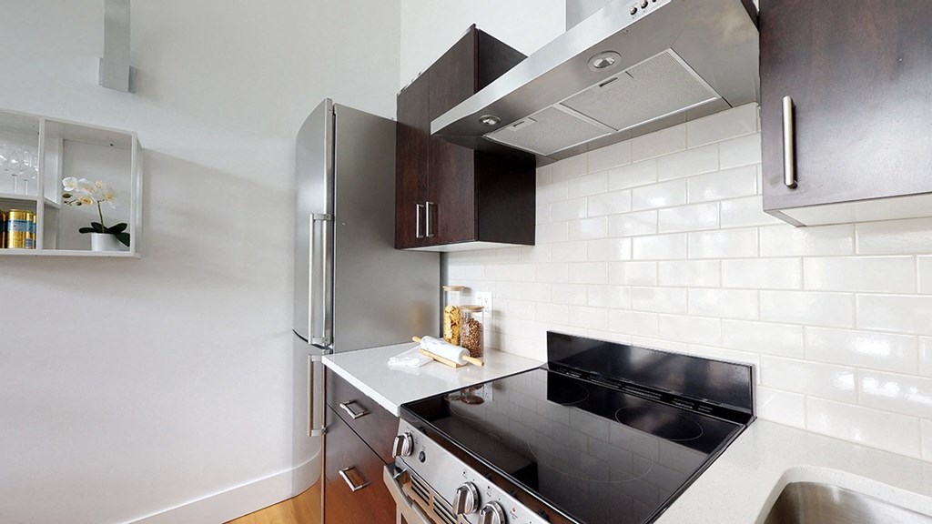 A modern kitchen with a black countertop and stainless steel appliances.