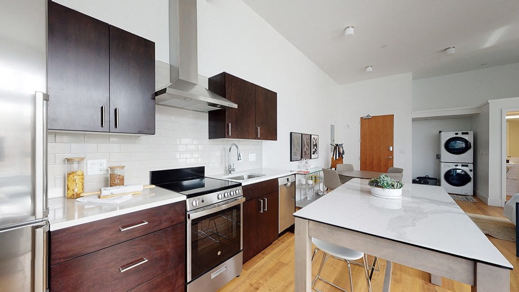 A modern kitchen with dark wood cabinets and stainless steel appliances.