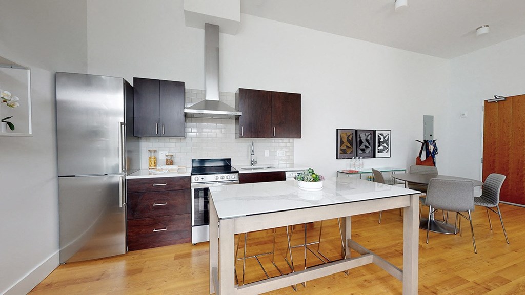 A modern kitchen with a wooden floor and white walls.