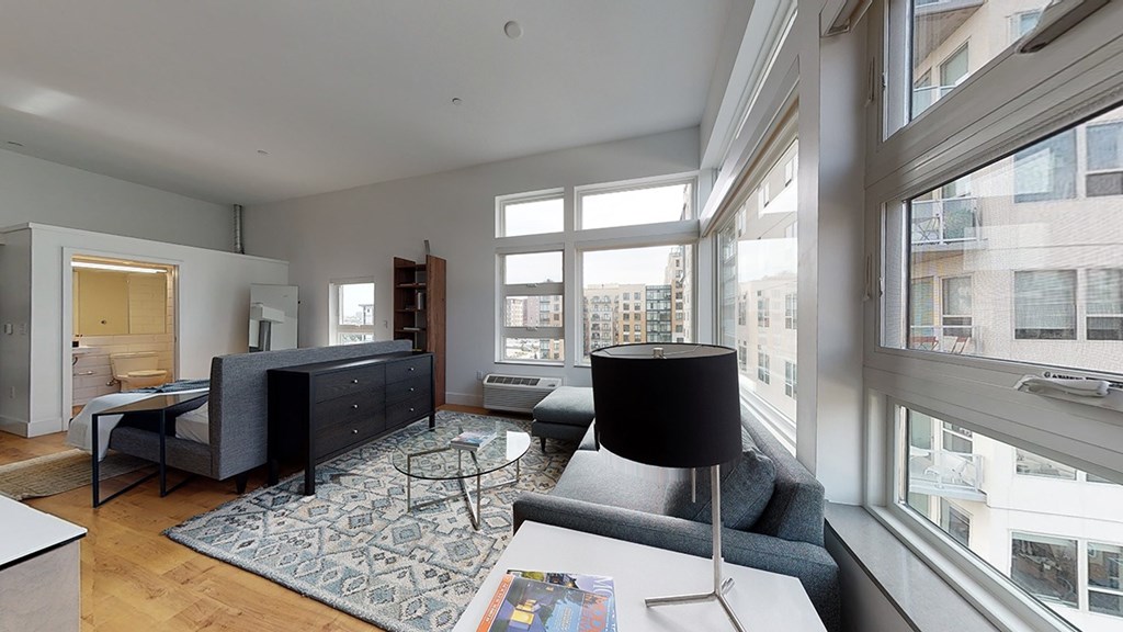A modern living room with a large window and a view of the city.