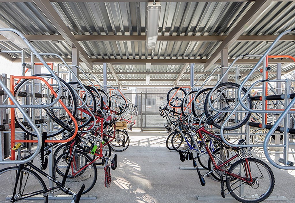 A bike rack full of bicycles in a parking area.