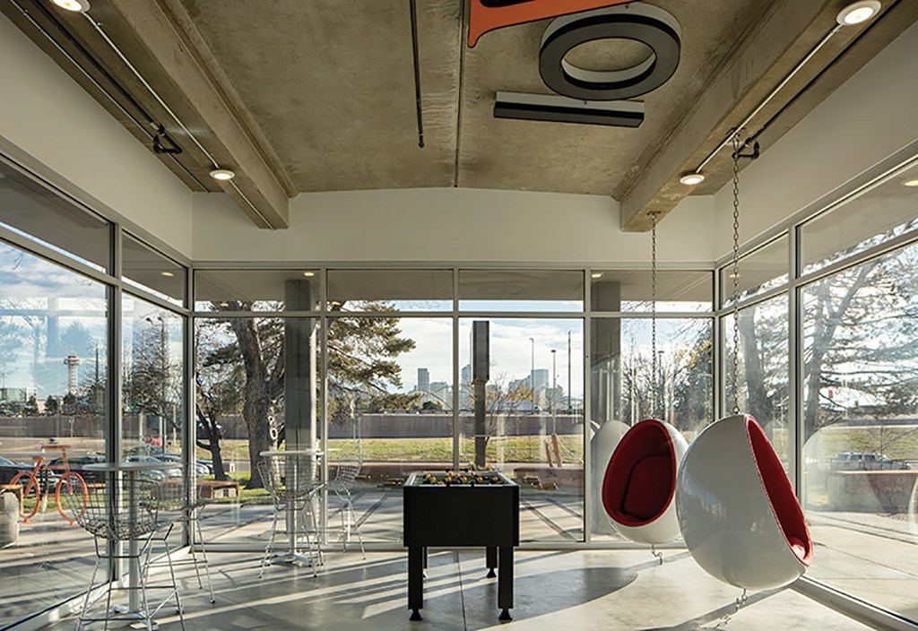A room with a piano and two egg-shaped chairs.