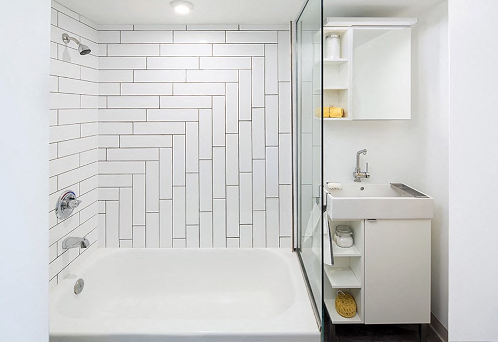 A white bathroom with a white tub and a white sink.