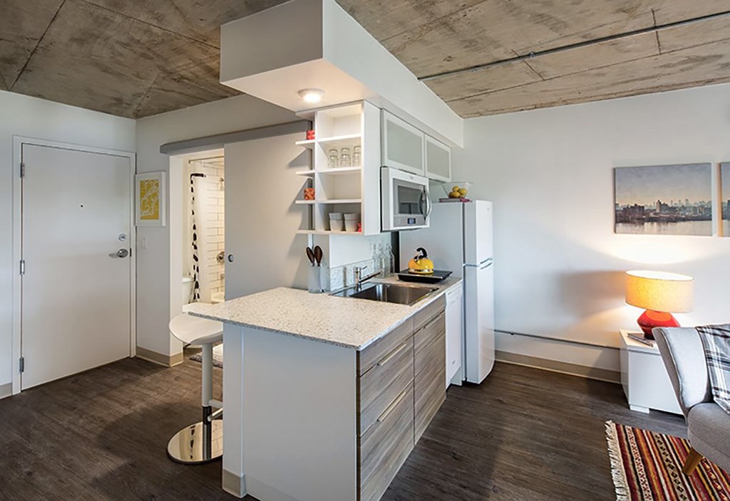 A modern kitchen with a white island and a refrigerator.