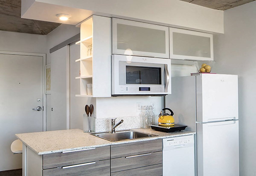 A modern kitchen with a white refrigerator, microwave, and stove.