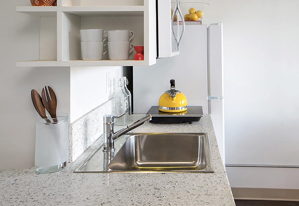 A kitchen with a sink and a refrigerator.