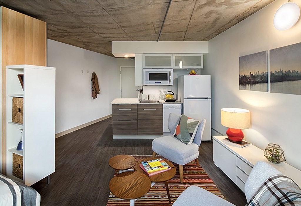 A modern kitchen with a refrigerator, microwave, and oven.
