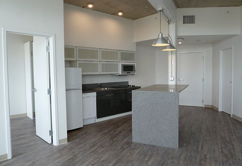 A kitchen with a black countertop and white cabinets.