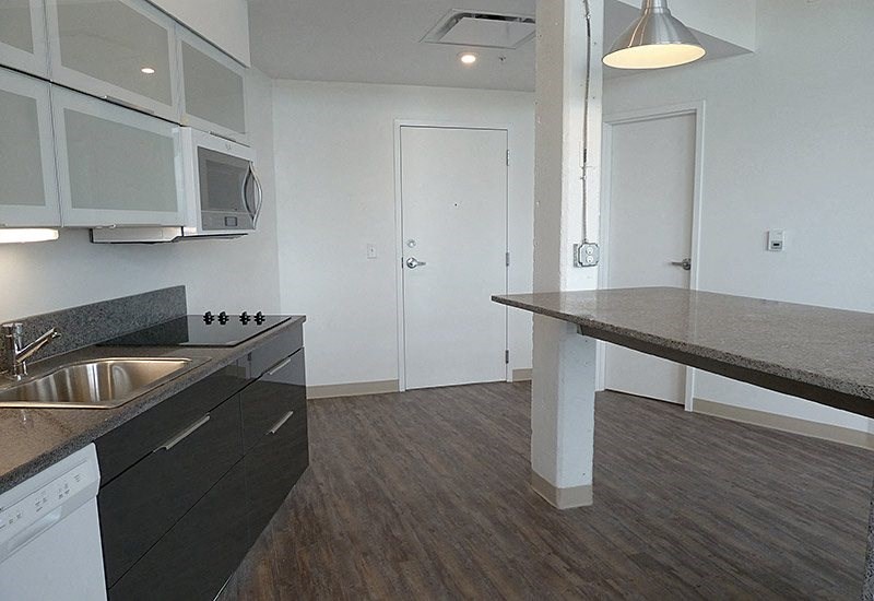 A kitchen with a sink, stove, and microwave.