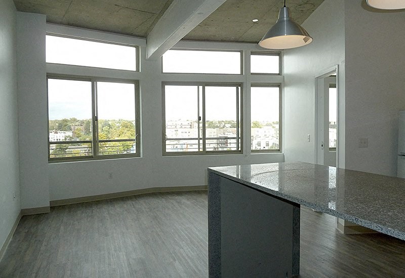 A large empty room with a concrete floor and a long counter.