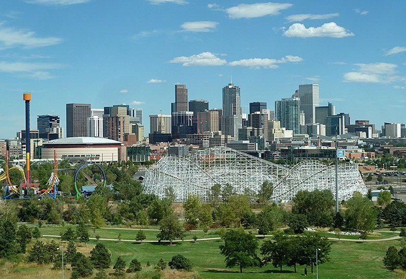 A city skyline with a large amusement park in the foreground.