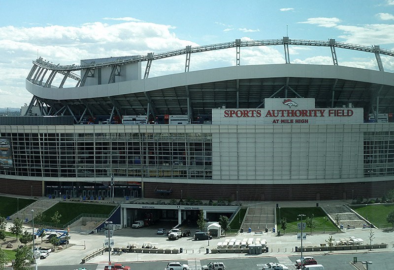A large stadium with a glass facade and a sign that reads