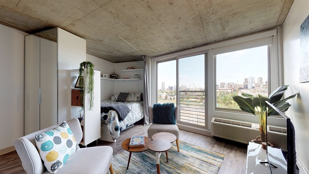 A bedroom with a bed, a chair, and a table.