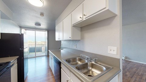 A kitchen with a sink and a refrigerator.