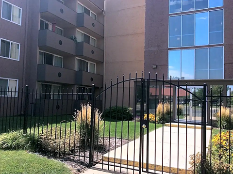 A black metal fence surrounds a building.
