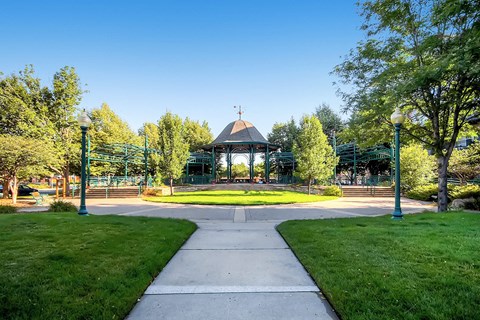 A gazebo is surrounded by trees in a park.
