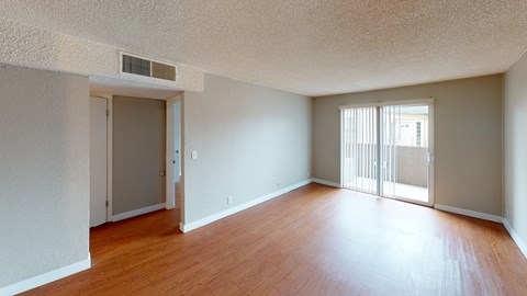 A room with wooden floors and a sliding glass door.