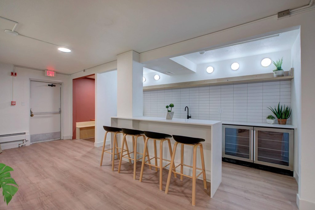A community kitchen area with a bar and stools.