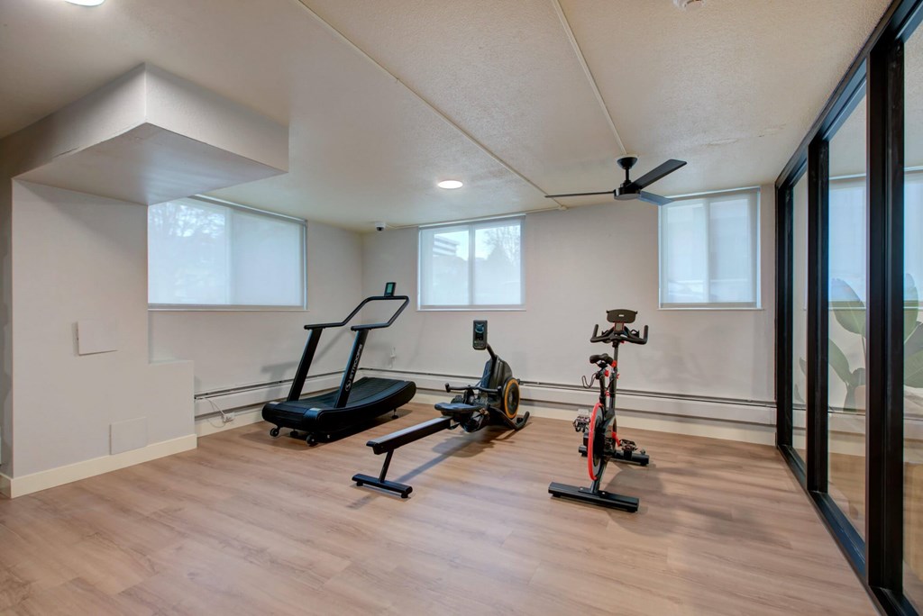 A room with a treadmill and a stationary bike.