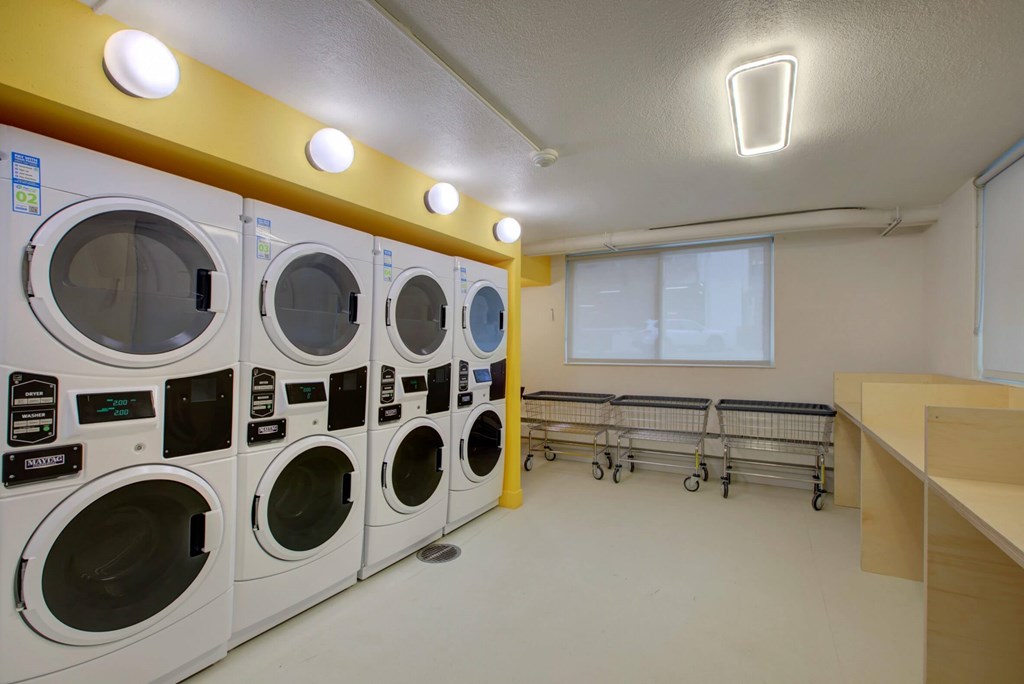 A row of stacked washers and dryers in a laundry room..