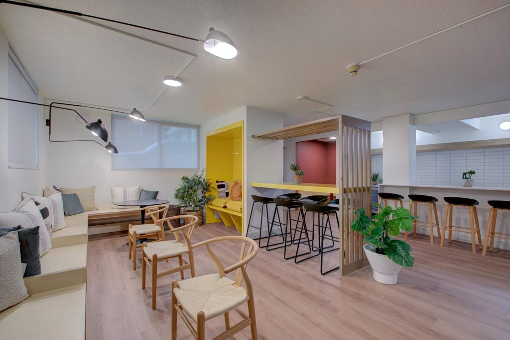 A community room with multiple seating options, including bar seating, nooks, and regular chairs.