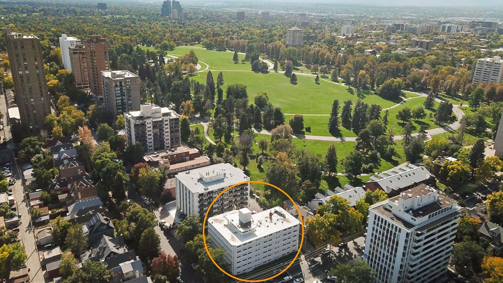 An aerial view of a city with a large white building circled in the middle.