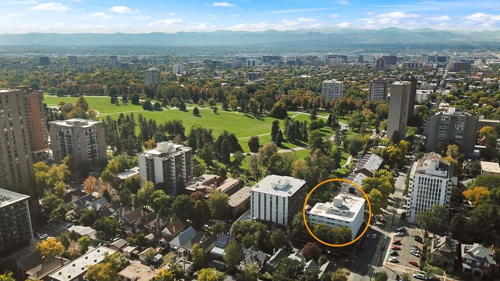 An aerial view of a city with a large building circled in orange.
