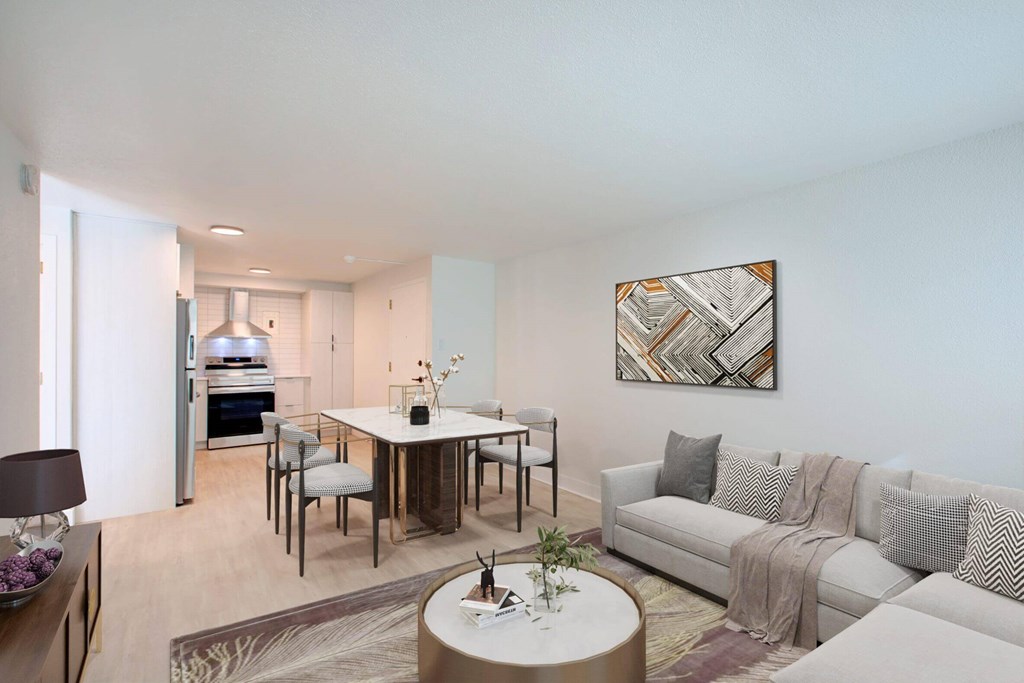 A modern living room with a white couch and a coffee table in the center.