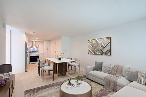 A modern living room with a white couch and a coffee table in the center.