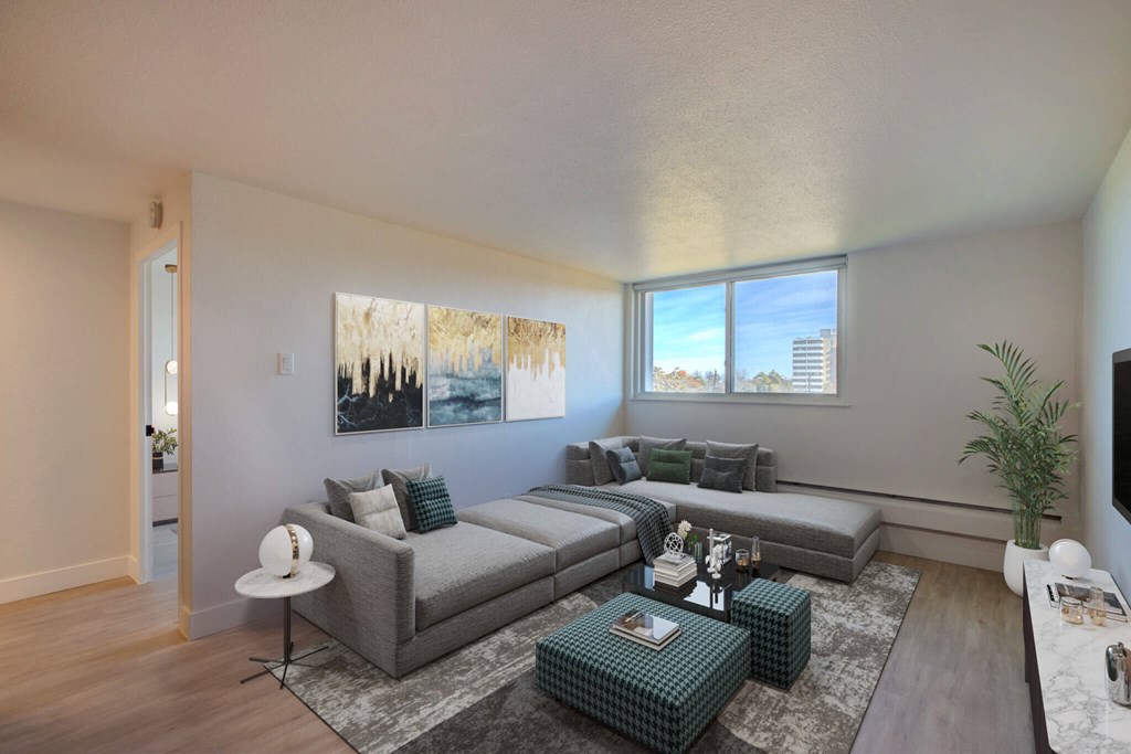 A living room with a grey couch and a green ottoman.