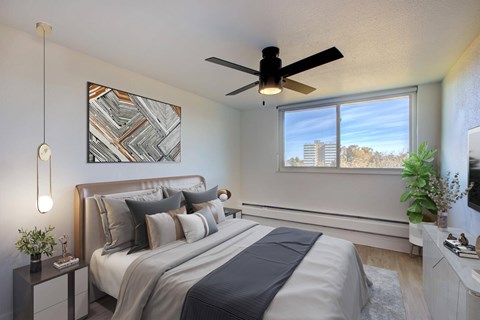 Modern bedroom with neutral bedding and ceiling fan at Belle on the Park Apartments, Colorado