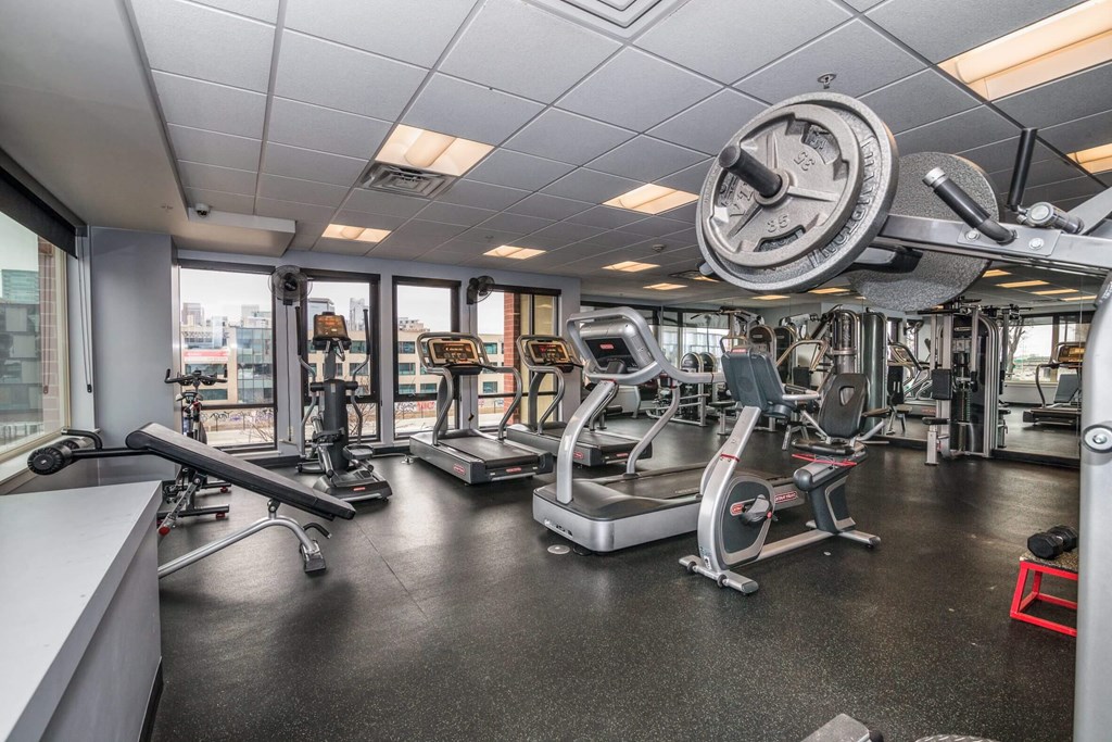 A gym with a variety of equipment including treadmills, weights, and exercise machines.