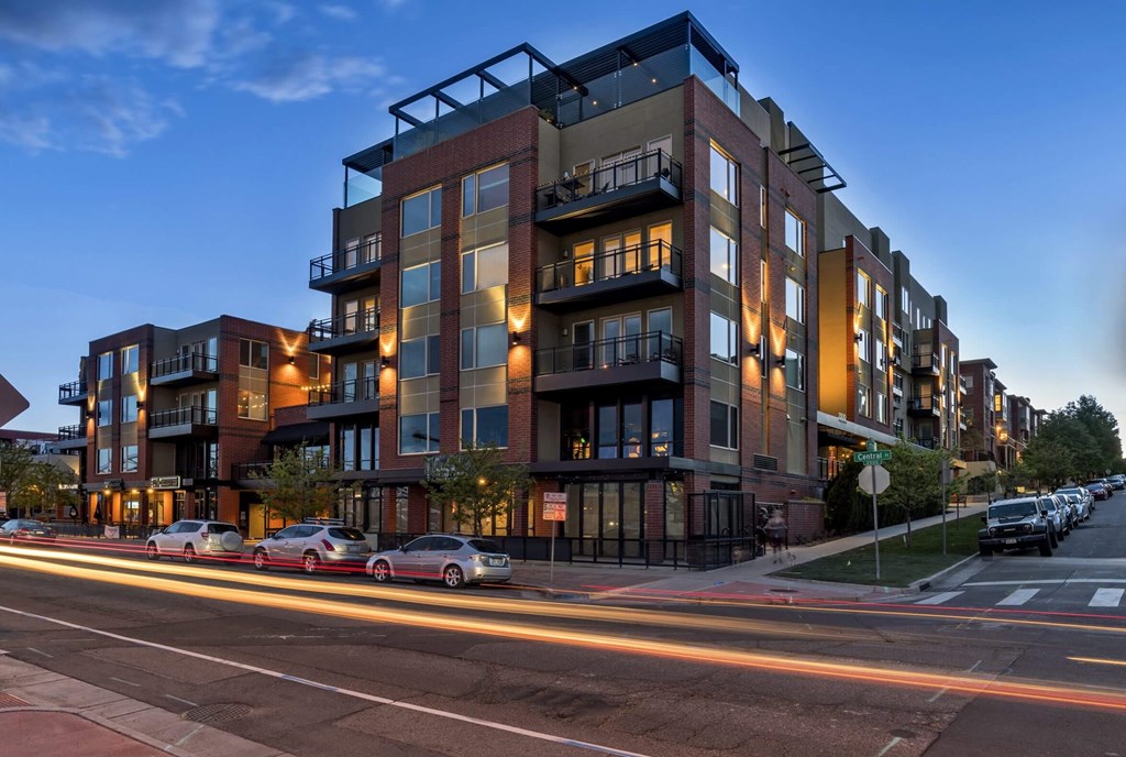A modern apartment building with cars parked in front.