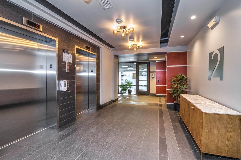 A hallway with a wooden bench and a chandelier.