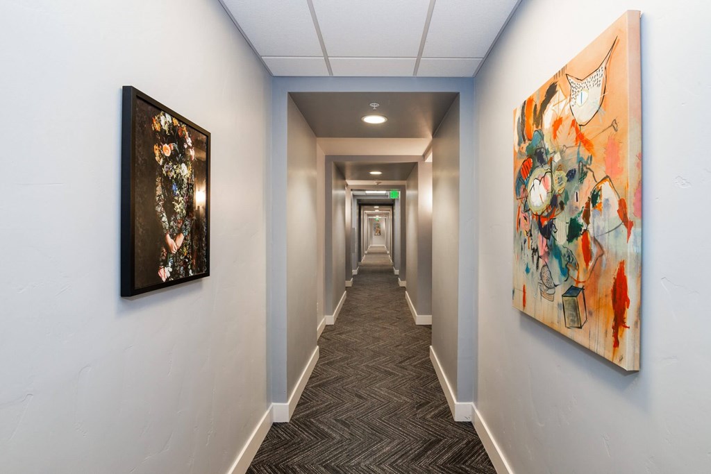 A hallway with two paintings on the wall.