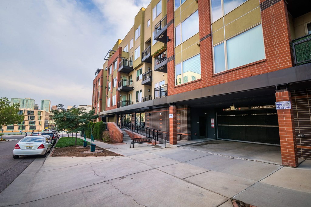 A multi-story building with a parking lot in front.
