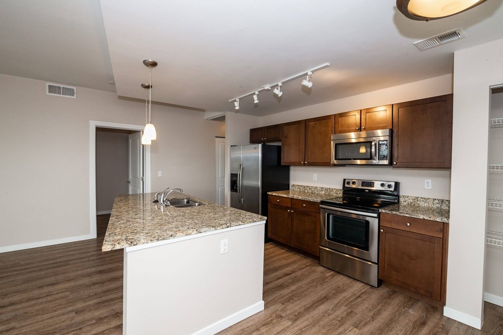 A kitchen with wooden cabinets and a granite countertop.
