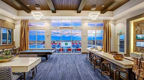 A large room with a pool table and a view of the ocean.