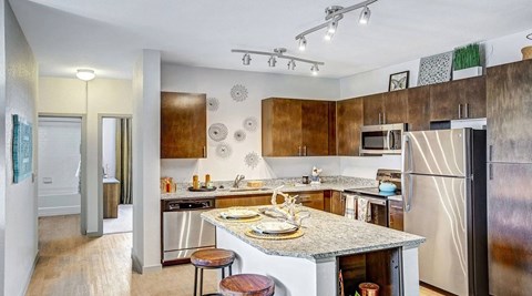 A kitchen with a refrigerator, stove, and microwave.