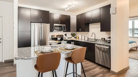 A modern kitchen with a table set for two.
