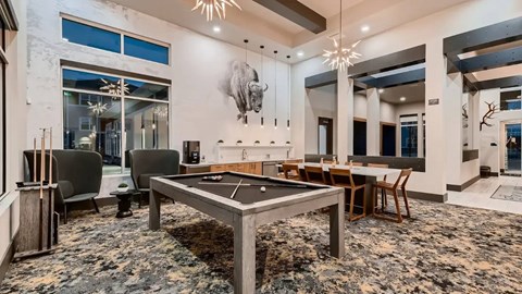 A room with a pool table and a large mirror on the wall.