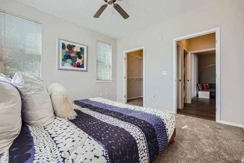 A bedroom with a bed and a ceiling fan.