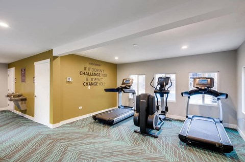A gym room with a motivational quote on the wall.