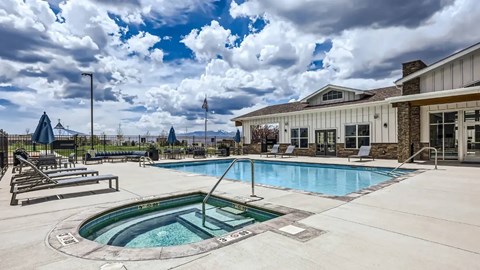 A large outdoor swimming pool with a hot tub in the middle.