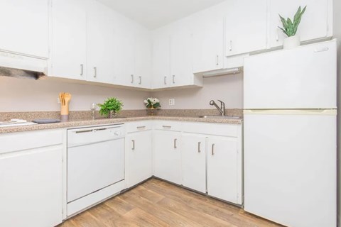 A kitchen with white cabinets and a white refrigerator.