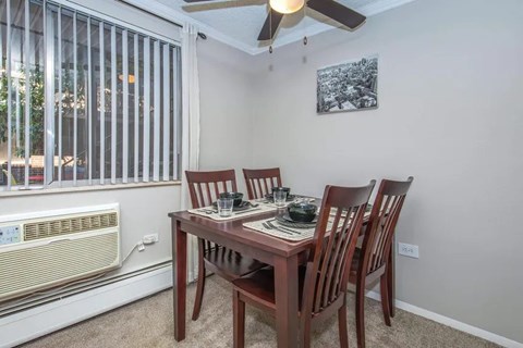 A dining room with a table set for four.