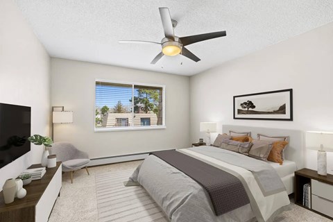 A bedroom with a large bed and a ceiling fan.